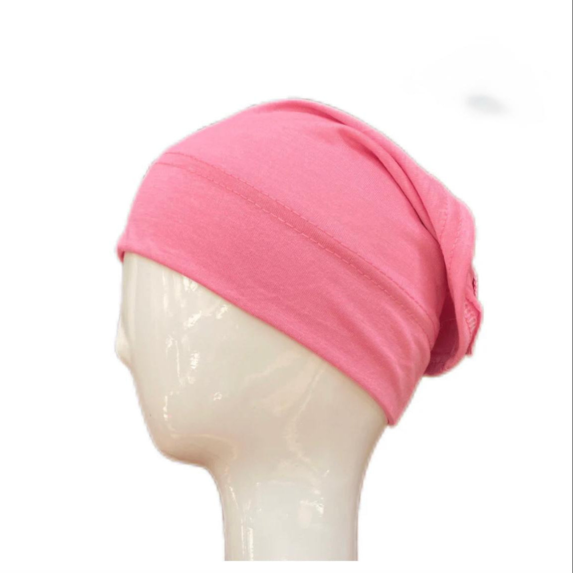 Pink headscarf on a mannequin head against a white background